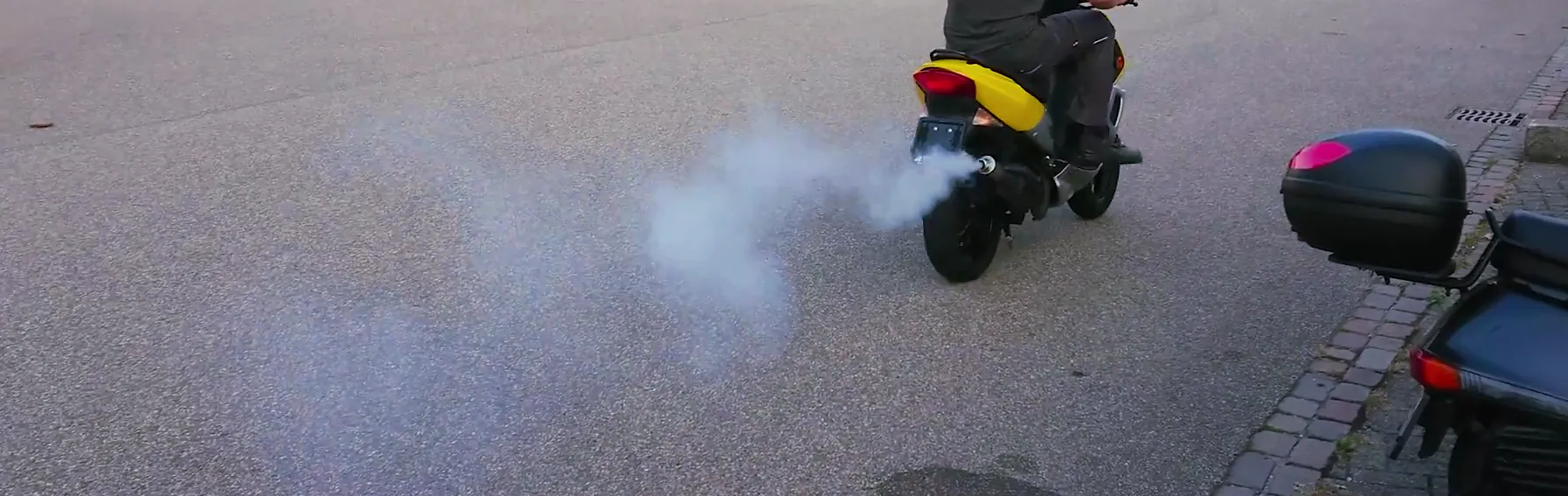 Polluting a motor scooter (Peugeot Speedfight 2) with two-stroke engine expels a jet of toxic exhaust fumes from the tailpipe