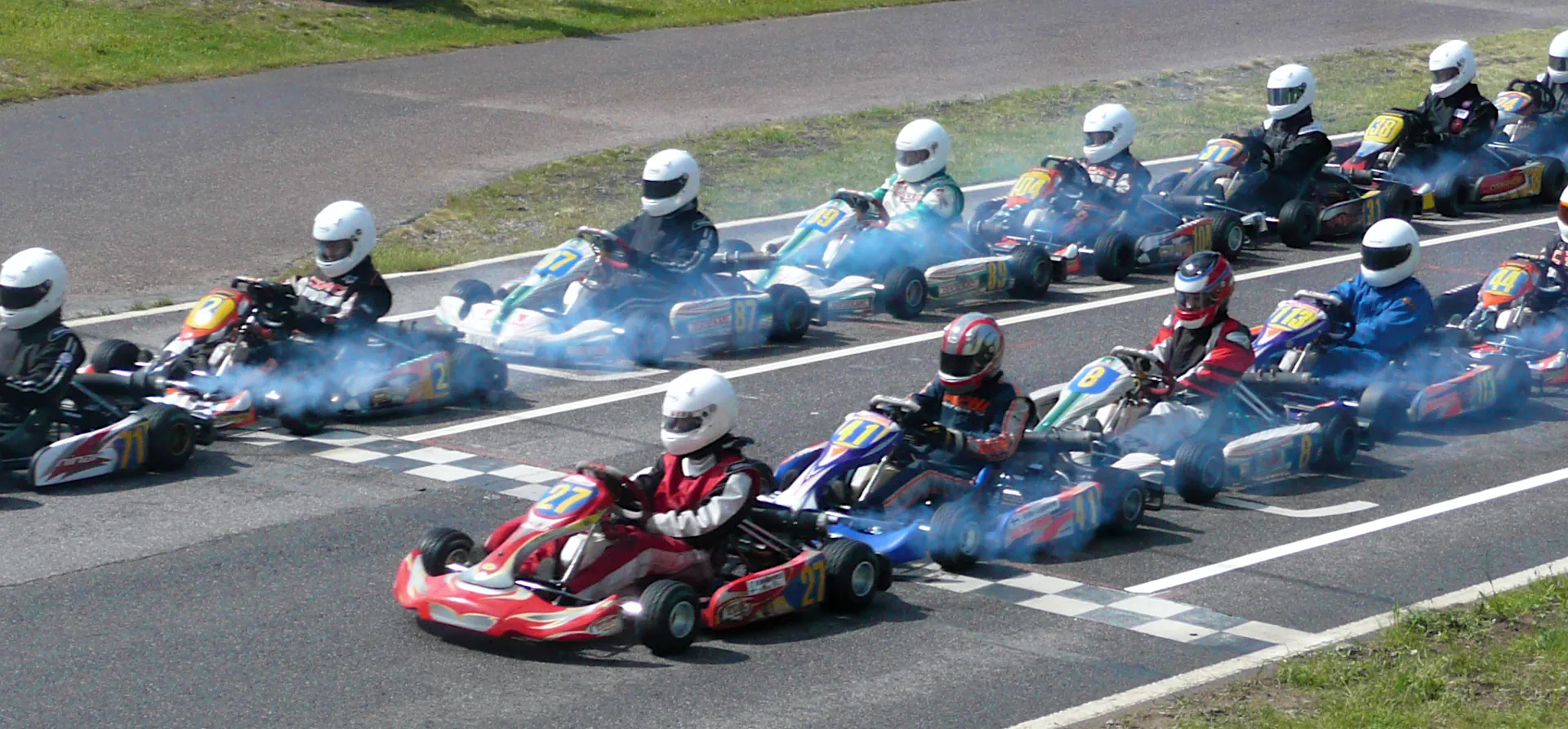 Thick clouds of exhaust at a karting race start. Go-kart drivers pollute the environment.