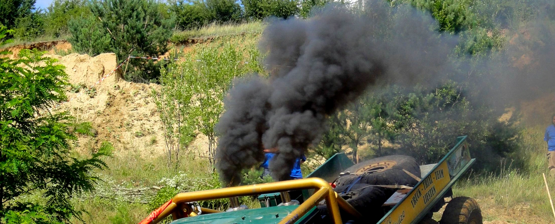 Motorsports pollution. A truck spews out a thick, black plume of sooty diesel exhaust at a truck trials event. Rolling coal!